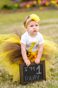 children's photography little blonde girl holding sign for one year photography session