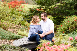 middle georgia engagement session tryphenas garden couple sitting on bride over water in flower garden