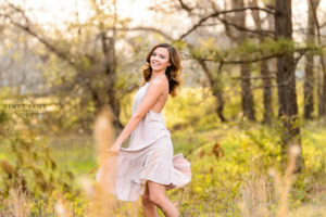 middle georgia senior portrait session, brown haired girl standing in field at sunset