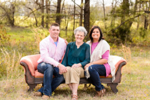 family sitting on couch in field in georgia for middle georgia family photography session, sunset, middle georgia family photo session