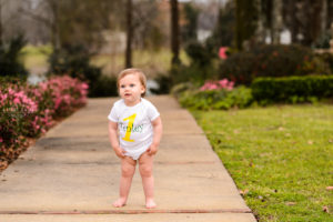 little blonde girl standing on walkway for one year photography session