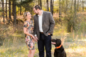 couple with dog in field for engagement session at sunset middle georgia