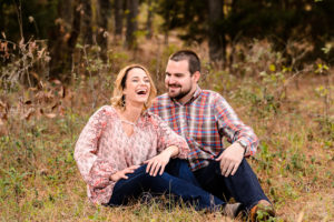 couple laughing in field during engagement session middle georgia