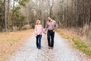 couple walking on gravel road in middle georgia for engagement session