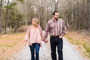 couple in pink walking on gravel road engagement session